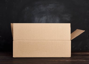kahverengi bir masanın üzerinde duran karton kutu, taşınma ve paketleme konsepti