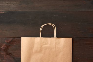 Kahverengi ahşap arka planda yiyecek ambalajı için kahverengi kese kağıdı, çevreyi kurtarmak için plastik torbaların reddedilmesi, üst görünüm