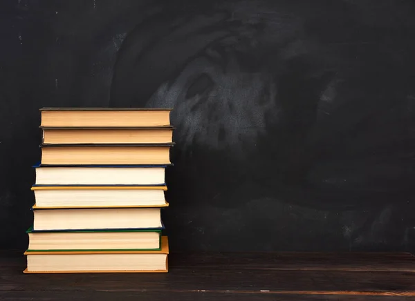 Pila Varios Libros Tapa Dura Fondo Una Pizarra Negra Vacía — Foto de Stock