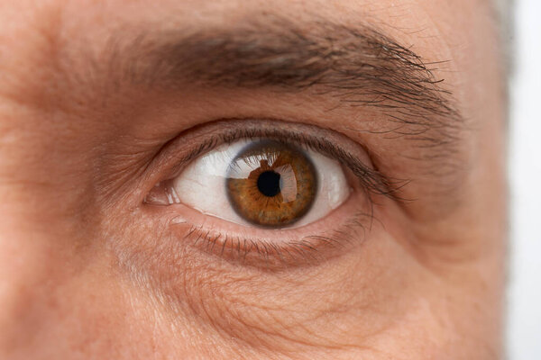 open eye on the face of an adult man with wrinkles, close up