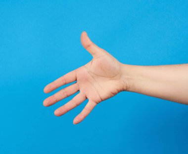 Uzanmış insan eli, açık el, vücudun bir parçası mavi arka planda, kapat