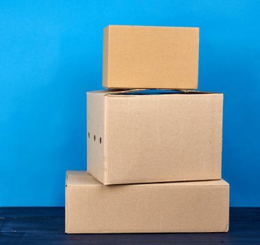 Mavi ahşap bir masa üzerinde kahverengi kraft kağıt karton kutular, hareket konsepti