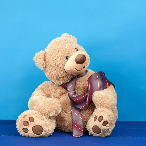 Brown Teddy Bear Sits Blue Wooden Background Tie Tied His — Stock Photo, Image