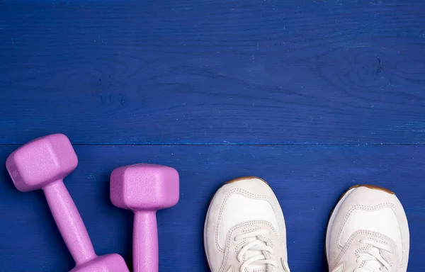 Rosa Plasthantlar Ett Kilo Och Vit Sportsko Blå Bakgrund Träningsutrustning — Stockfoto