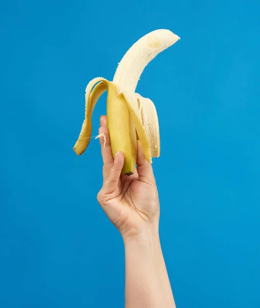 Female Hand Holds Ripe Peeled Banana Blue Background Close — Stock Photo, Image