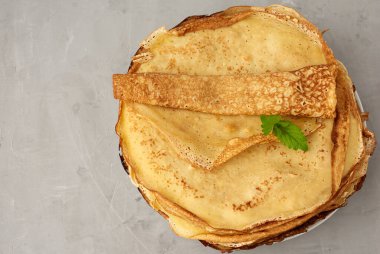 Tabakta kızarmış yuvarlak krep yığını, gri arkaplan, üst görünüm, boşluk kopyala