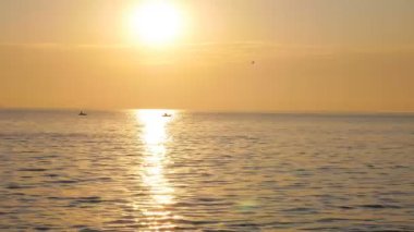 Sunrise Sun denize nerede uçan kuşlar ve Parlatıcı yansıtan dalgalar üzerinde