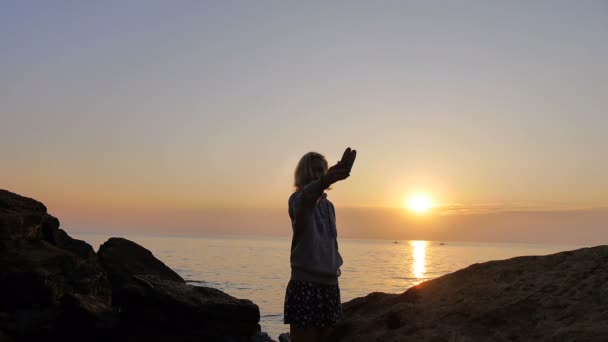 Девушка делает селфи на восходе солнца над морем, где летают птицы — стоковое видео