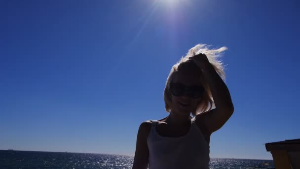 Meisje glimlachend en geniet van een moment in de zon van zonsopgang boven de zee waar vogels vliegen — Stockvideo