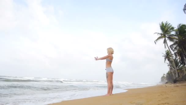 Junge Frau mit schlanker Figur turnt auf See — Stockvideo