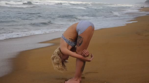 Jeune femme avec une silhouette mince est engagé dans la gymnastique en mer 
