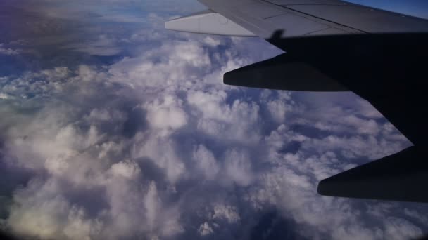 Kijk door het raam van een vliegtuig in de blauwe lucht in de wolken — Stockvideo
