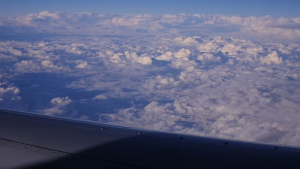 Blick durch ein Flugzeugfenster in den blauen Himmel in Wolken — Stockvideo