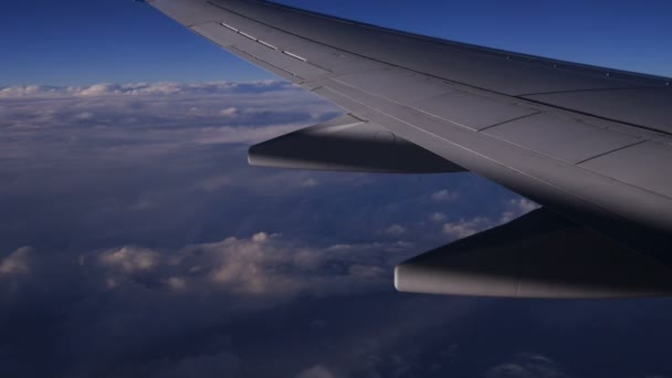 Вид на горы из окна самолета над землей в голубом небе в облаках — стоковое видео