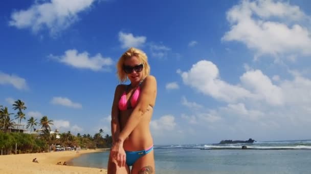 Sommermädchen mit Sonnenbrille am Strand von Sri Lanka im rosa Bikini