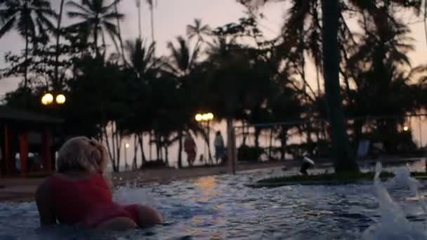 Sexy chica joven disfrutar de jacuzzi lado de la piscina, sonriendo al atardecer, Sri Lanka — Vídeo de stock