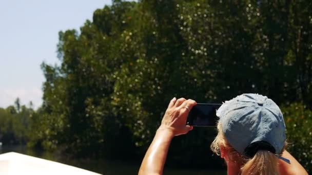 Vrouw schieten op de aard van een mobiele telefoon aan de rivier Kalu Ganga in Sri Lanka — Stockvideo