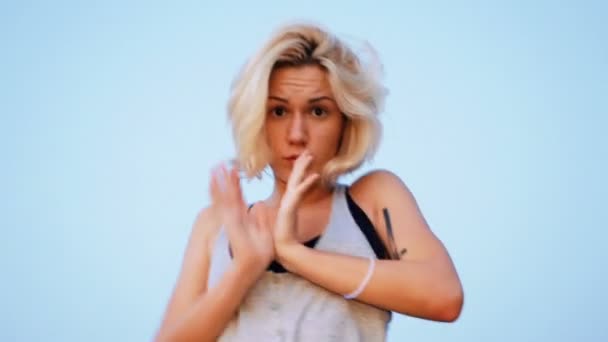 Beautiful blond girl dances on the beach at sunrise and birds on the background — Stock Video