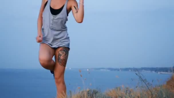 Gyönyörű szőke lány táncol a tengerparton a napkelte és a madarak a háttérben — Stock videók