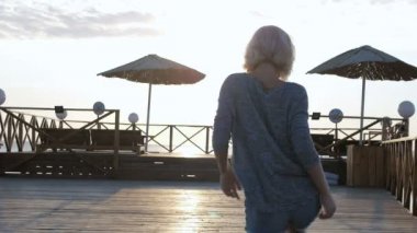 Sarışın kız kot şort plaja yakın beautuful güneş doğarken mutlu dans