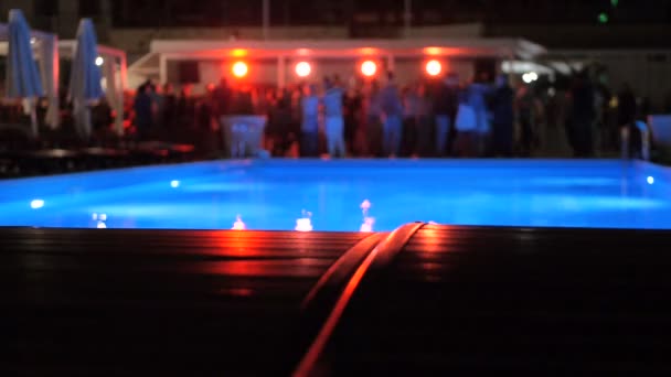 Světla, soustružení v nočním klubu u bazénu, když lidé tancují rozmazané — Stock video