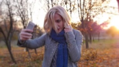 Genç kadın mutluluk selfie günbatımı sonbahar renkli yaprakları arasında
