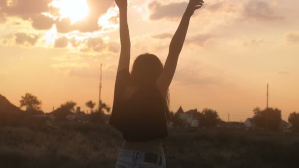 Close-up van meisje dansen gelukkig in de zonsondergang — Stockvideo