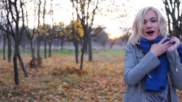年轻女孩幸福运行和隐藏在秋天的落叶在日落 — 图库视频影像