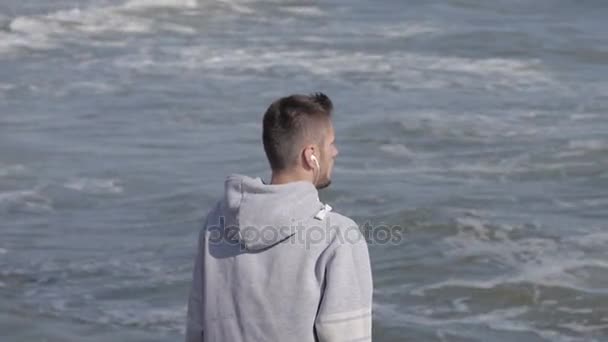 Hombre corriendo al amanecer en la playa — Vídeo de stock