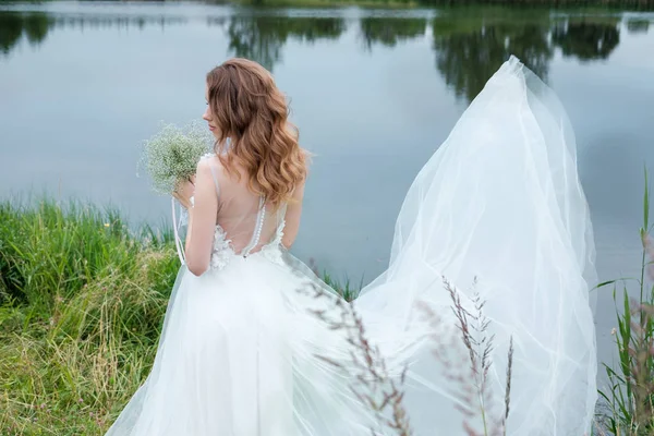 Mooie jonge vrouw (bruid) in witte trouwjurk buitenshuis, maken — Stockfoto