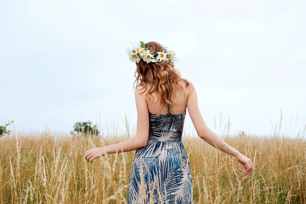 portrait of young pretty woman with circlet of camomile flowers 