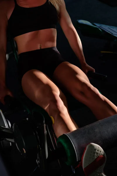 Deportivo chica delgada haciendo ejercicio en las piernas en el gimnasio, de cerca —  Fotos de Stock