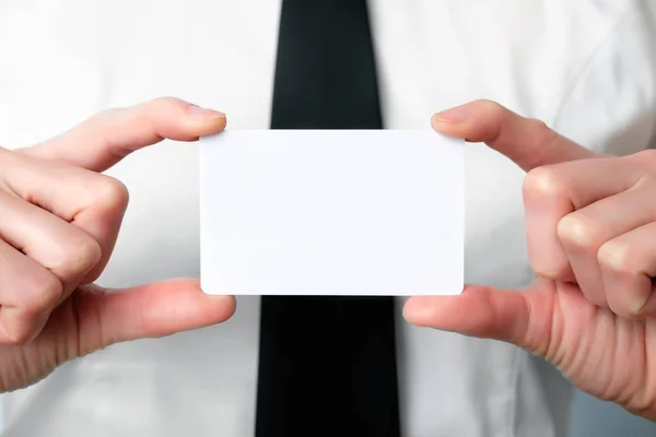 employee of the bank offers a plastic card, close up, copy space
