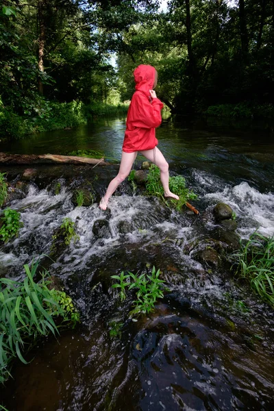 Pies de mujer en zapatillas amarillas de pie en el tronco sobre el río, de cerca — Foto de Stock