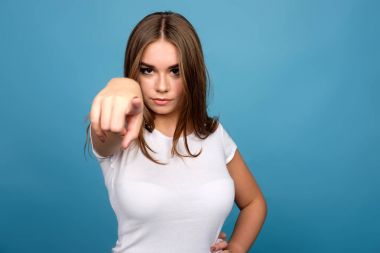 Beyaz t-shirt ileri foref ile işaret eden genç esmer kız