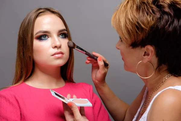 Maquiagem artista fazendo maquiagem para jovem morena bonita mulher em s — Fotografia de Stock