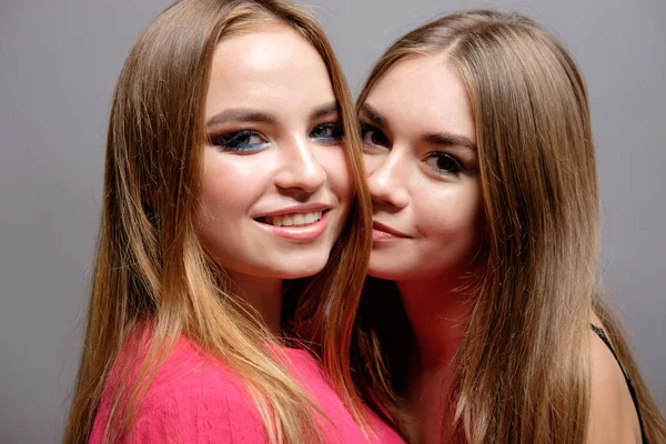 Studio portret van twee jonge mooie meisjes, knuffelen make-up werk — Stockfoto