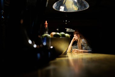 bar (pub) içme buzlu kokteyli ve SMIL oturan Kızıl saçlı kız