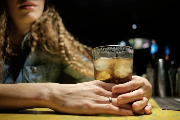 redhead girl sitting in bar (pub) drinking icy cocktail alone