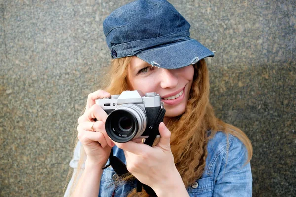 Retrato de pelirroja joven sonriente mujer en gorra con cámara fotográfica — Foto de Stock