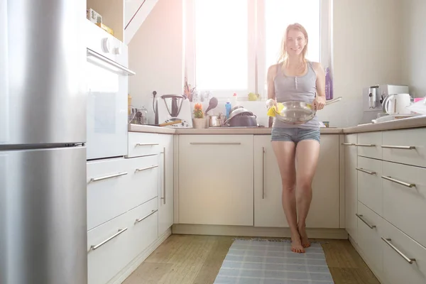 Young woman washing dishes in the kitchen — Stock Photo, Image