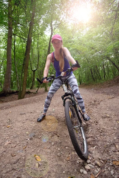 Молода дівчина в спортивному одязі з їздою на велосипеді в лісі влітку — стокове фото