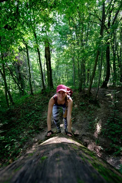 Fille randonnée dans la forêt, escalade jusqu'à la bûche — Photo