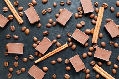 kahve çekirdekleri ile çikolata parçaları ve tarçın siyah arka plan düz görünüm üzerinde