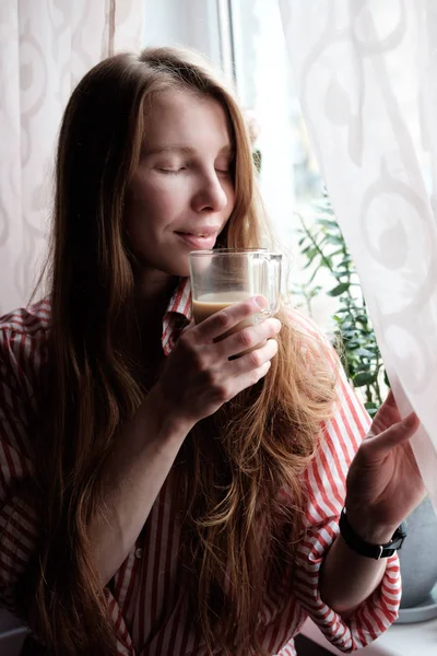 Рыжая женщина пьет кофе по утрам — стоковое фото
