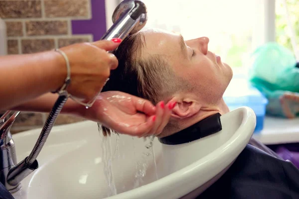 Peluquería lavar el cabello a un hombre joven — Foto de Stock