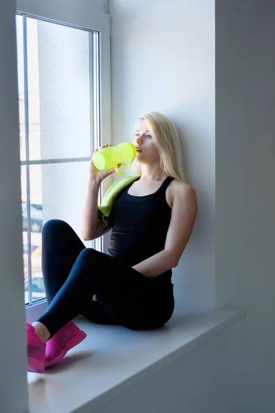 Mujer joven beber agua en el gimnasio —  Fotos de Stock