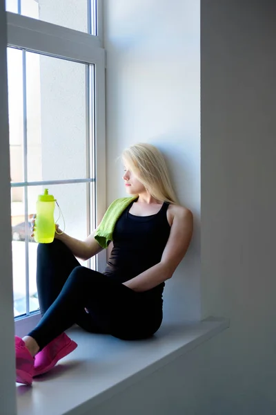 young woman drink water in the gym