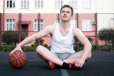 Basketbol tutarak ve uzak seyir çekici adam