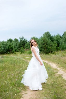 Beyaz gelinlikle açık havada, genç güzel gelin makyaj ve 